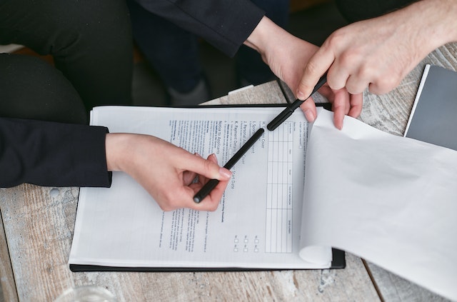 person holding a lease agreement and a pen